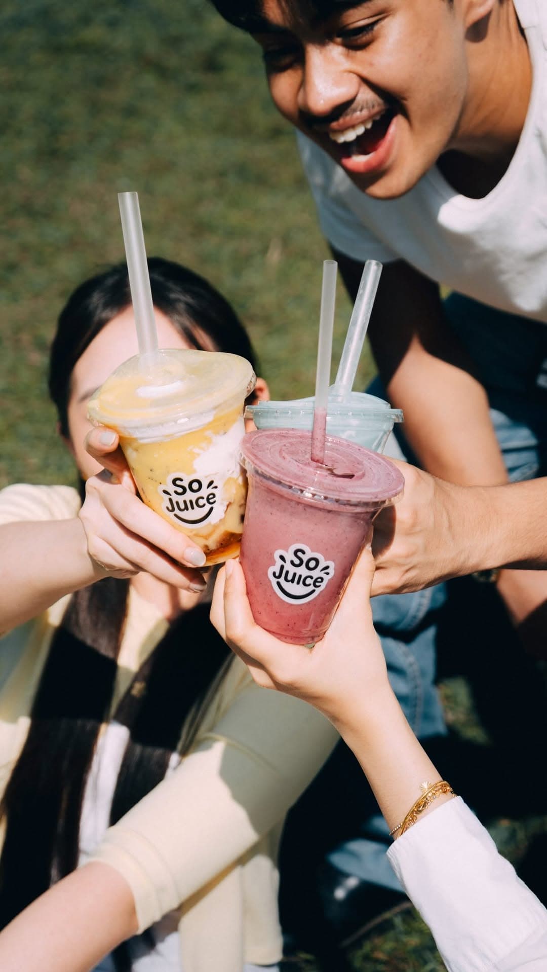 Two SoJuice cups raised in a toast